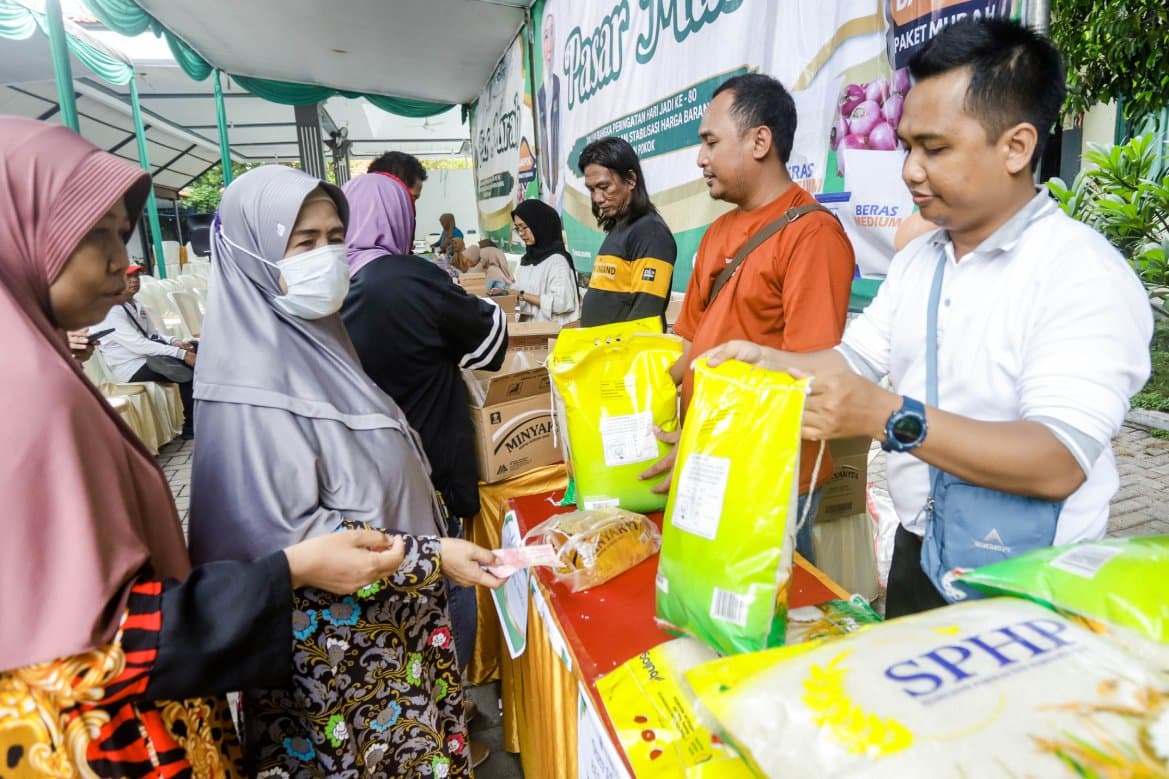 LAKU KERAS: Operasi pasar murah di kantor Kelurahan Medokan Semampir diserbu warga, Rabu (5/11). Telur, minyak, dan beras jadi sembako favorit yang diburu.