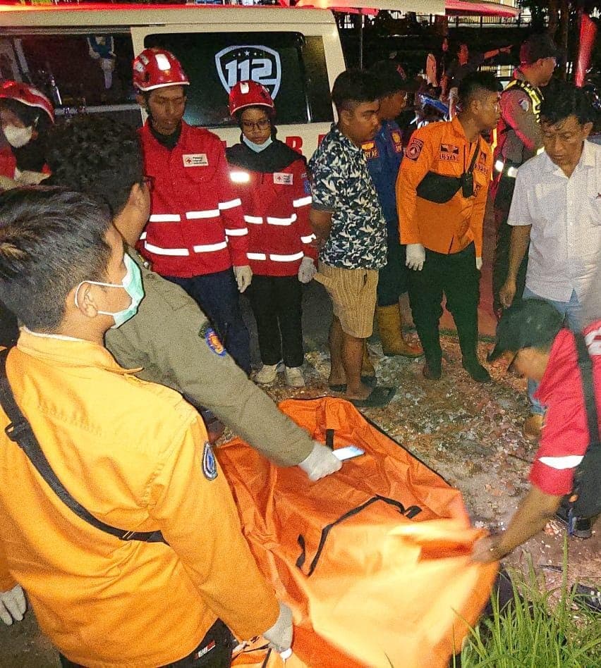 MENINGGAL DI TEMPAT: Petugas mengevakuasi jenazah AD yang diduga menjadi korban tabrak lari di Jalan Kalimas Barat, Sabtu (1/11) malam.