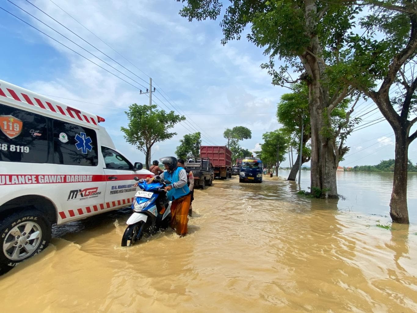 TERHAMBAT: Sejumlah pengendara harus berhati-hati saat melintas di tengah banjir di Desa Jrengik, Kecamatan Jrengik, Sampang, pada Rabu (19/11).
