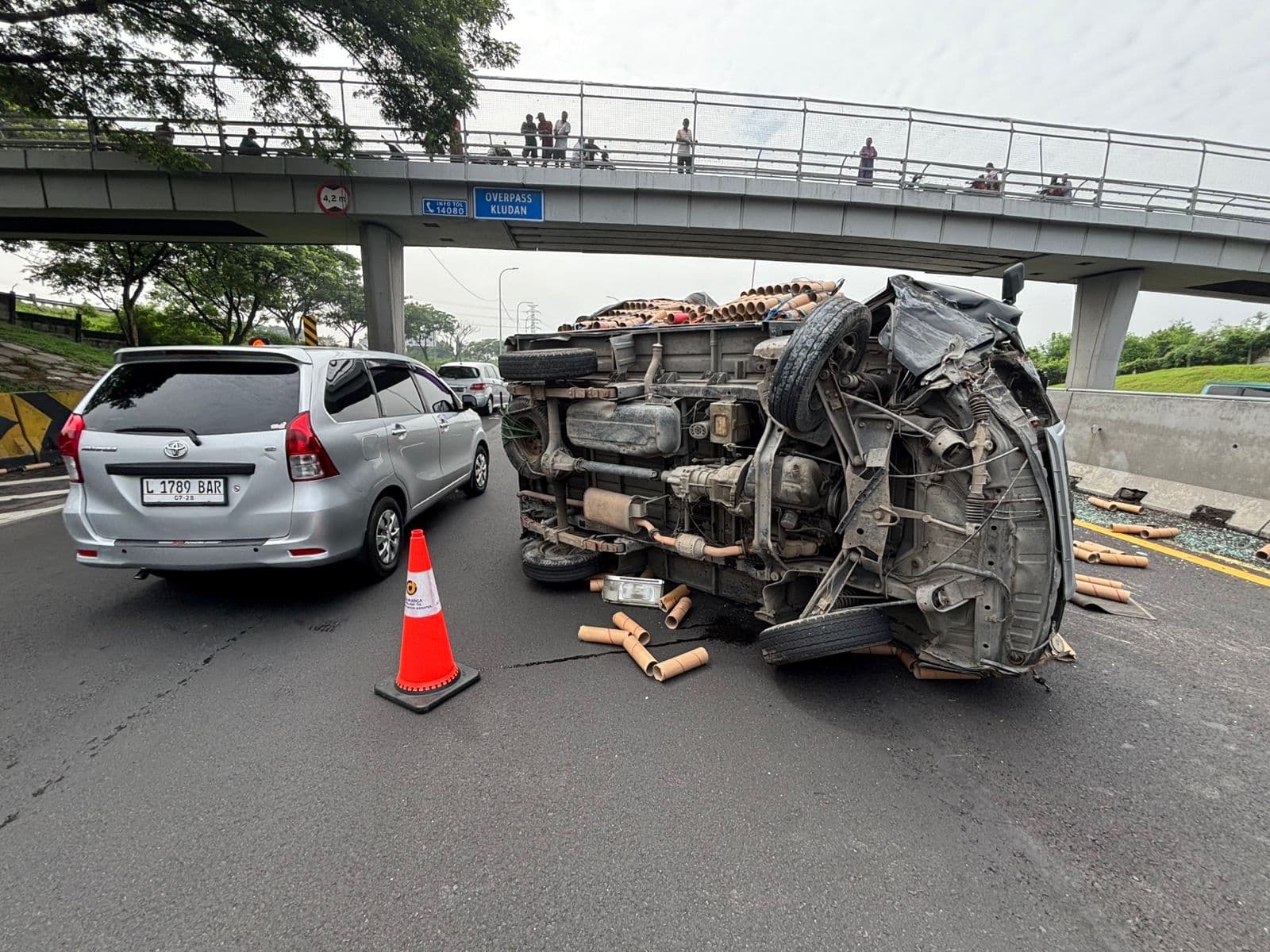 HAMBAT LALU LINTAS: Pikap bernopol  L 9562 BI menutup jalur tol arah Malang. Muatannya berserakan dan menganggu perjalanan pengendara lain.