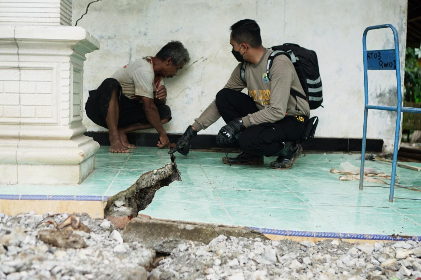 DAERAH RAWAN: Petugas gabungan memeriksa salah satu bagian rumah warga yang amblas dan menggantung akibat tanah gerak di Desa Jombok, Trenggalek, pada Rabu (19/11).