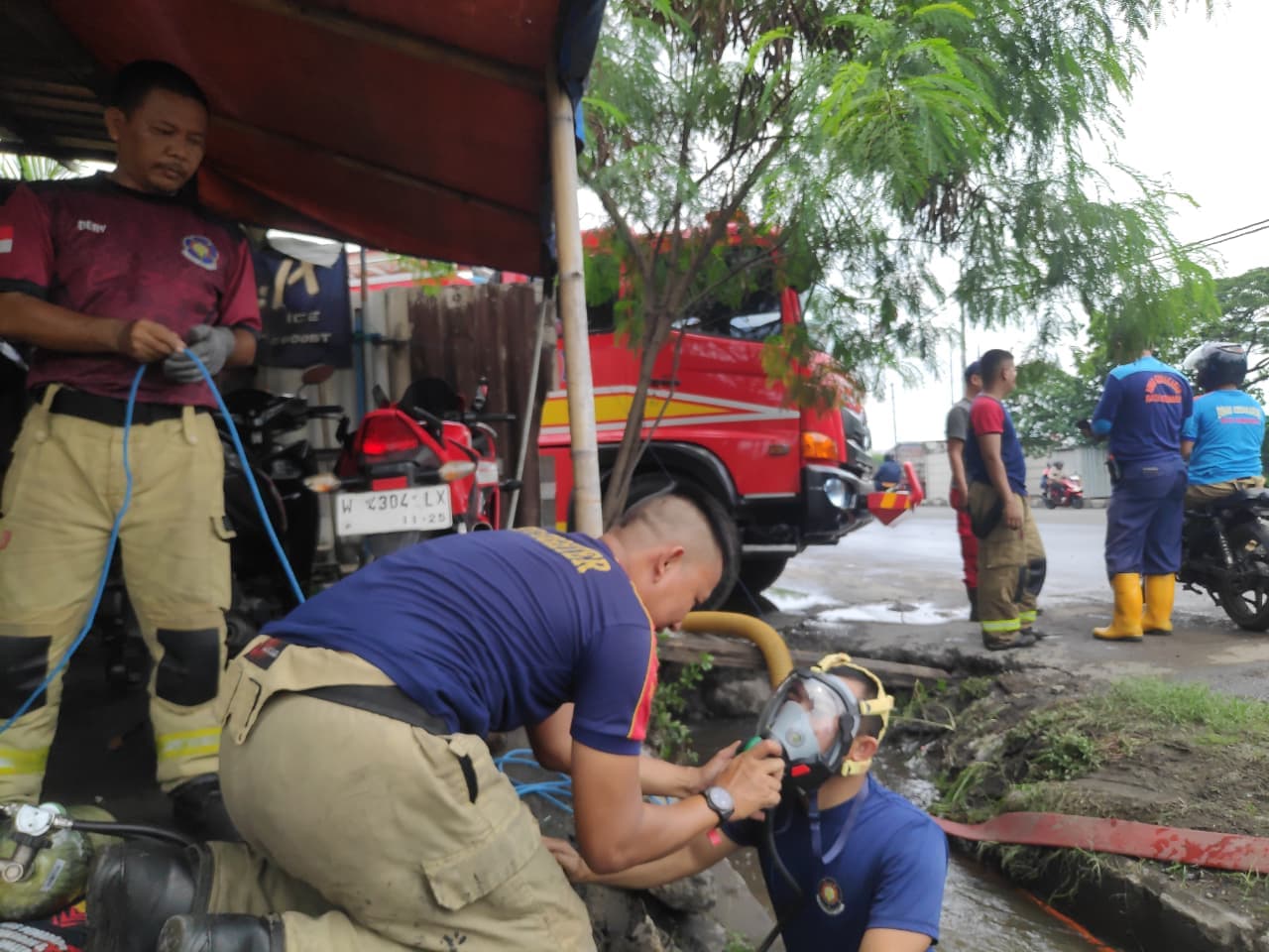 BONGKAR SUMBATAN : Tim Rescue DPKP Surabaya memakai alat selam untuk membersihkan saluran di Jalan Tambak Langon Rabu (12/11).