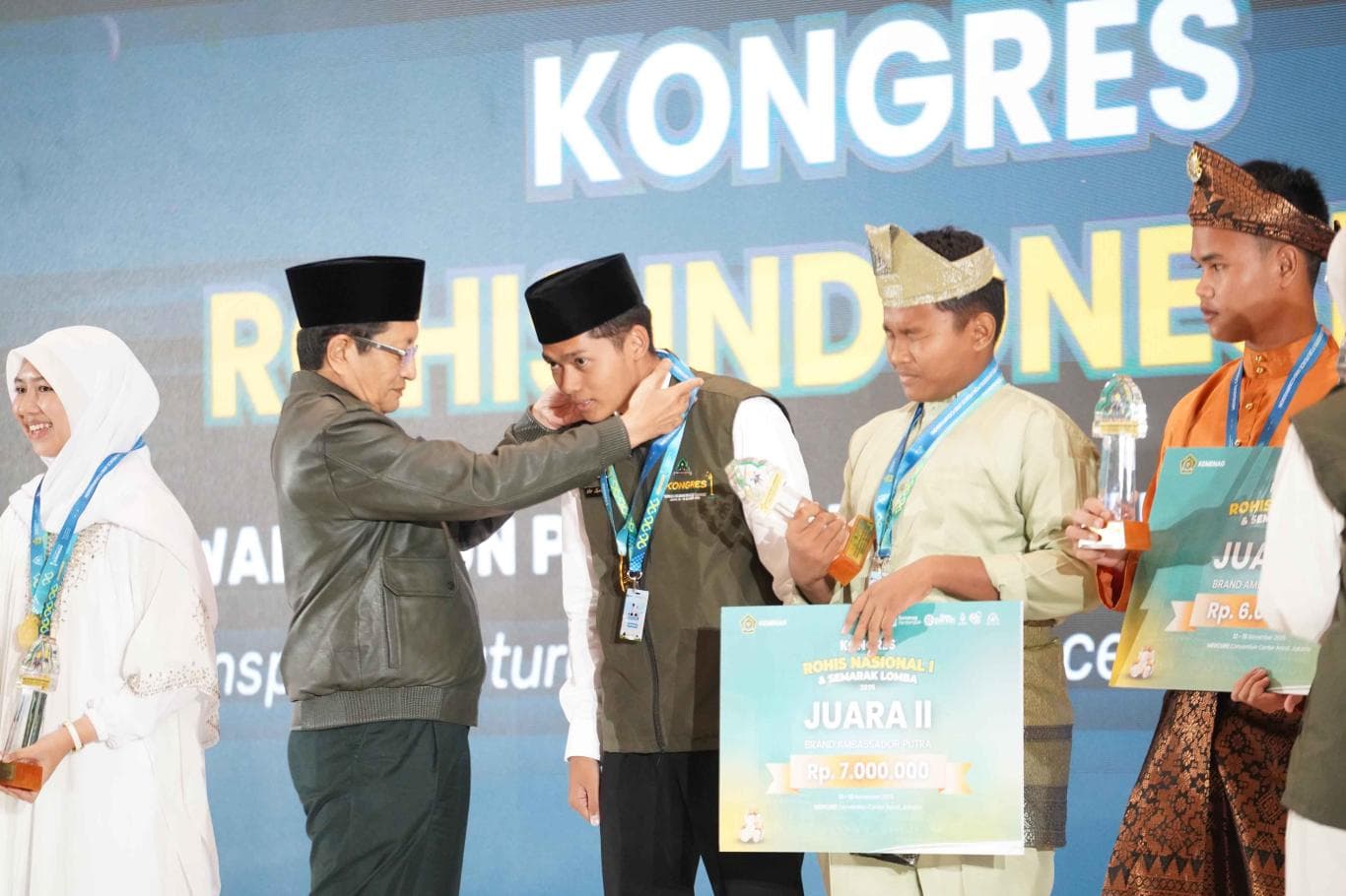 APRESIASI: Nasaruddin Umar mengalungkan penghargaan kepada pemenang brand ambassador Rohis dalam Kongres Rohis Nasional I 2025 di Jakarta.