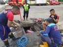 BONGKAR SUMBATAN : Tim Rescue DPKP Surabaya dan Anggota Pos Tambak Osowilangon membersihkan saluran hampir dua jam di Jalan Tambak Langon Rabu (12/11).