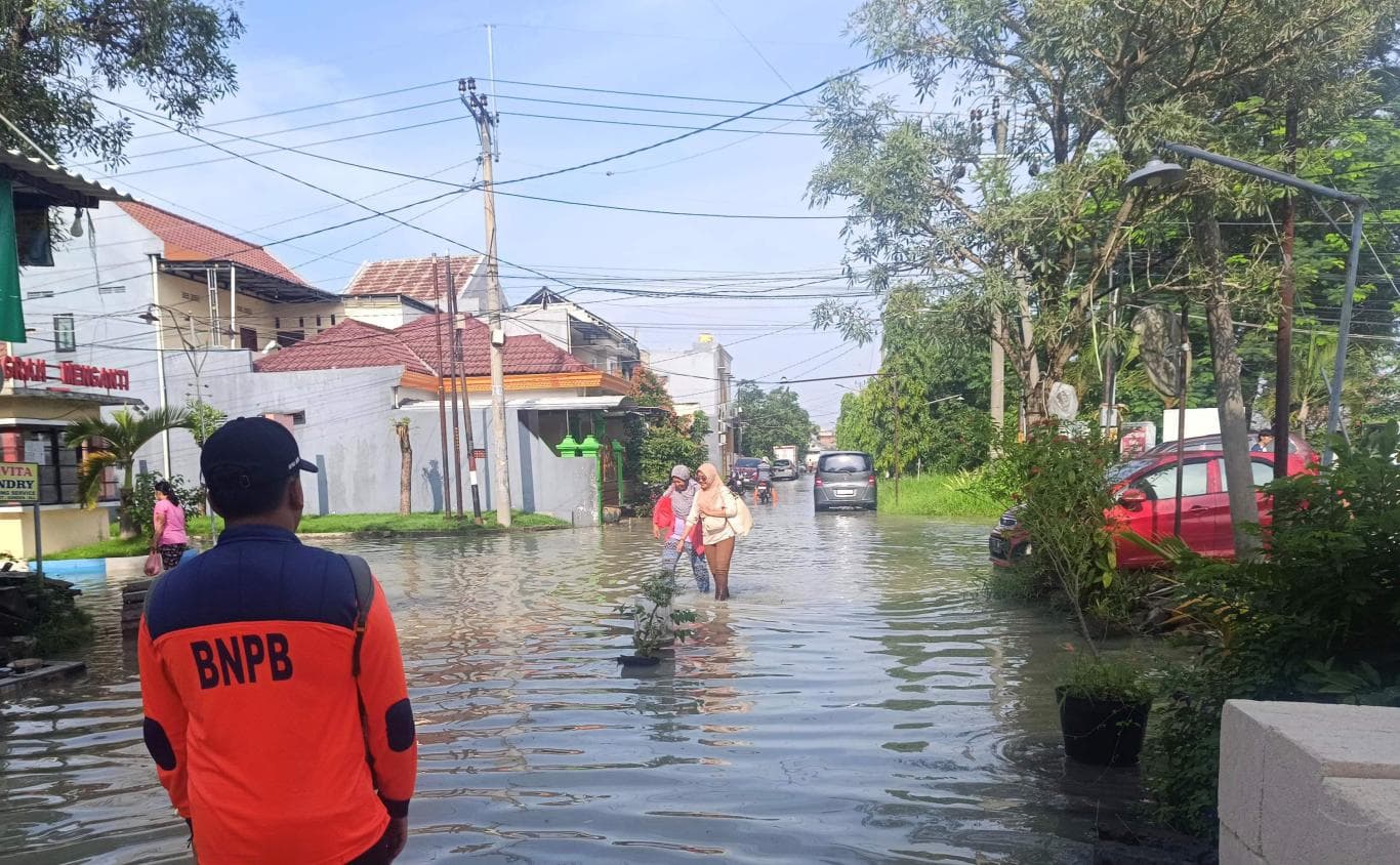 GENANGI JALAN: Banjir akibat luapan Kali Lamong meluber ke jalan desa dan sebagian permukiman warga di wilayah Desa Bringkang, Menganti. Hingga Rabu (19/11), sungai sepanjang 132 kilometer itu masih berstatus siaga merah.