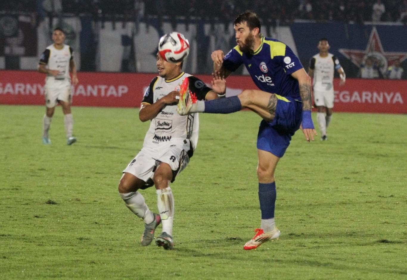 KERAS: Pemain Persija Jakarta Witan Sulaeman (kiri) Witan berebut bola dengan pemain asing Arema FC Odivan Koerich di Stadion Kanjuruhan (8/11).