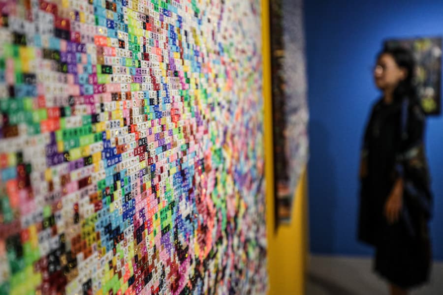 Seniman Agus Baqul menghadirkan karya Dunia Atas Bawah dan No Holyday No Holyland berupa manik-manik huruf penuh warna.