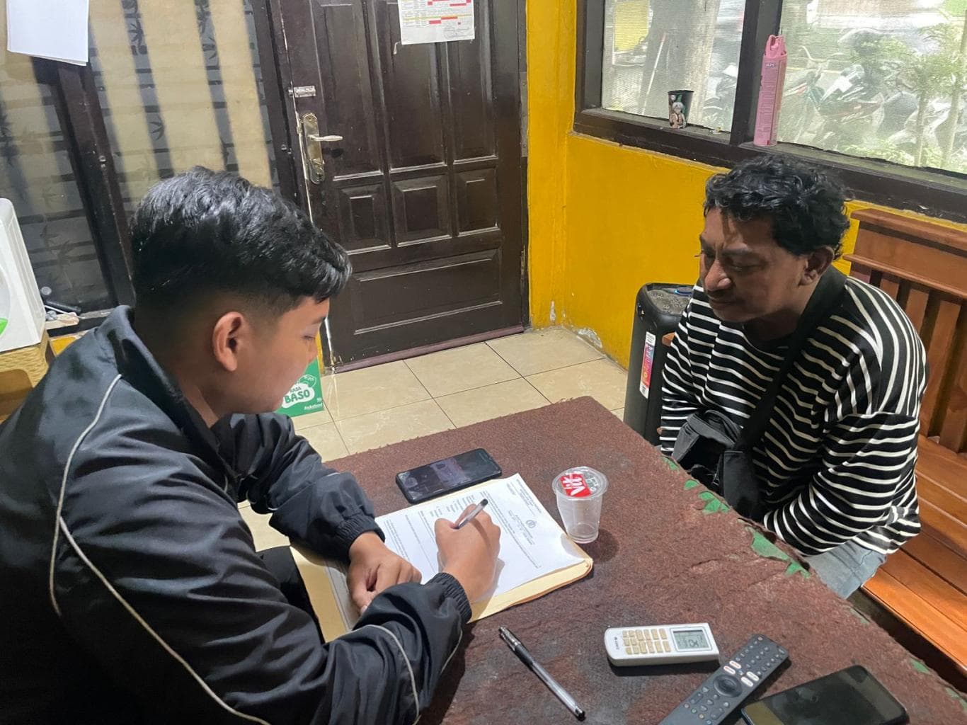 HASIL PANTAUAN: AP, kurir miras dengan sistem COD saat menjalani pemeriksaan oleh petugas di Mapolres Gresik kemarin (13/11).