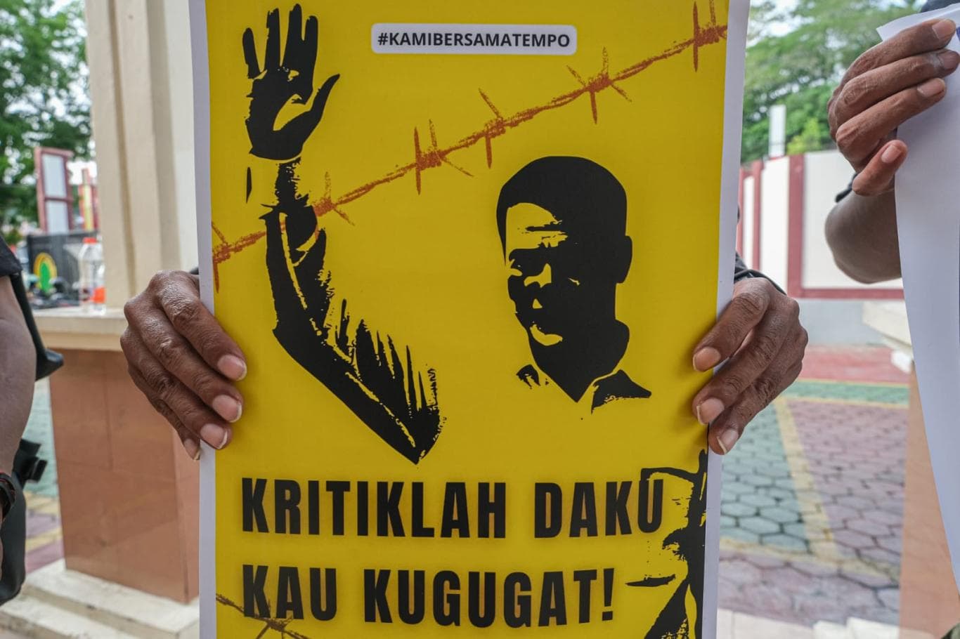 PERS BERSATU: Jurnalis memegang poster saat aksi solidaritas mendukung Tempo di Pengadilan Negeri Kendari Kelas IA, Sulawesi Tenggara, Kamis (6/11/2025).