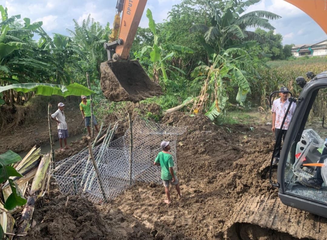 UPAYA DARURAT: Tim gabungan pemkab memperbaiki tanggul anak Kali Lamong di Desa Cermen yang sempat jebol kemarin (17/11).