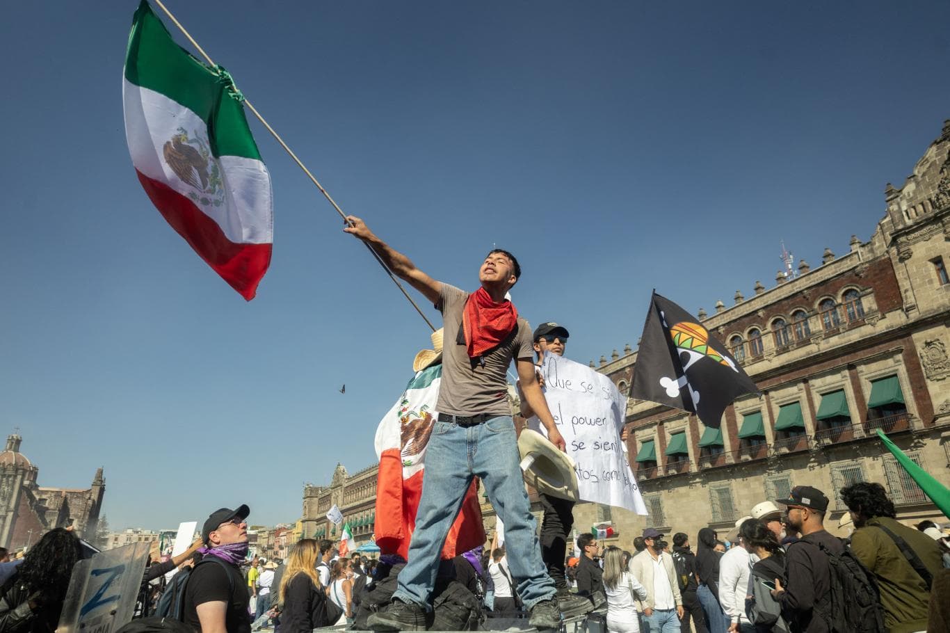 LAWAN NARKOBA: Seorang demonstrans mengibarkan bendera Meksiko dalam unjuk rasa memprotes kekerasan terkait narkoba dan kebijakan keamanan pemerintahan Presiden Claudia Sheinbaum di Lapangan Zocalo, Mexico City, Sabtu (15/11).