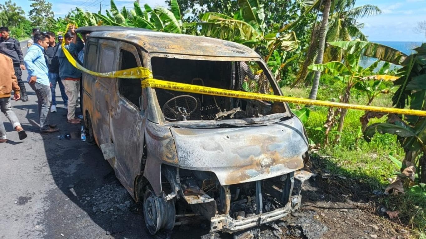 HANGUS: Garis polisi dipasang di sekeliling mobil yang terbakar Rabu (12/11). Mobil yang membawa uang Rp 4,6 miliar itu terbakar di Jalan Trans Sulawesi Palippis, Kabupaten Polewali Mandar, Sulawesi Barat.